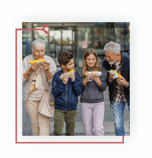 Outdoor photo of senior couple with a grandchildren walking and eating 